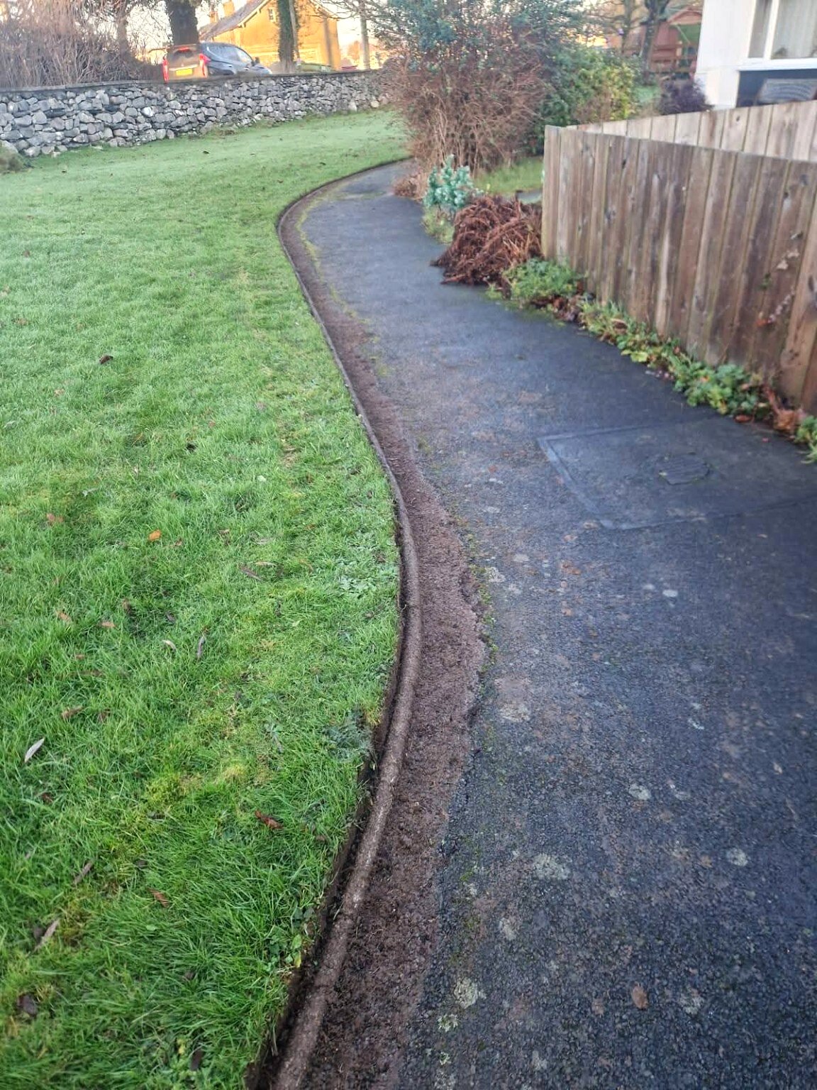 Crisply cut curved lawn edge beside a pathway